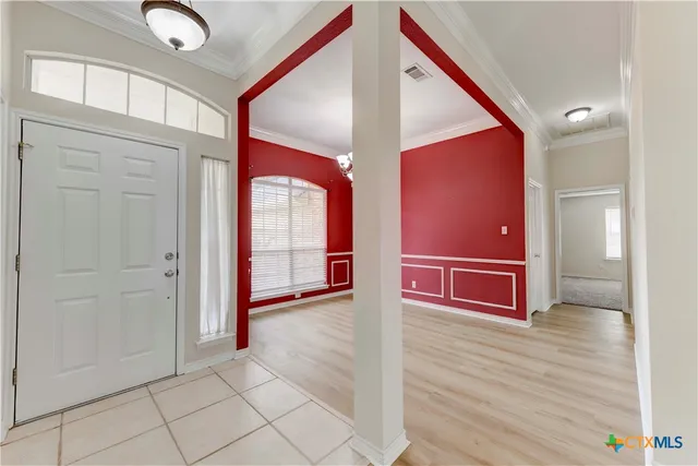 a view of a hallway with wooden floor and chandelier