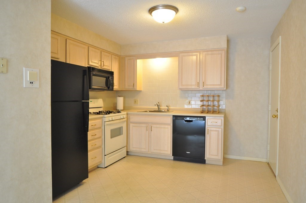 90 Beacon Street, Unit 8 Lawrence, MA 01843 - Photo 6 of 26 a kitchen with a refrigerator stove and microwave