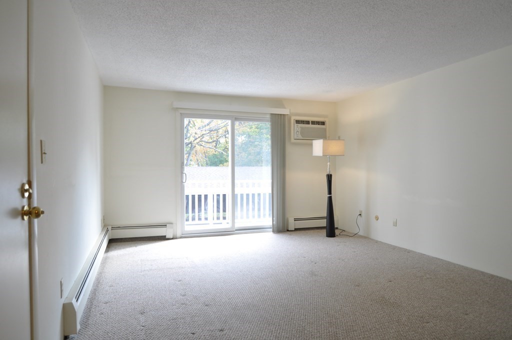 90 Beacon Street, Unit 8 Lawrence, MA 01843 - Photo 7 of 26 an empty room with chandelier fan and windows