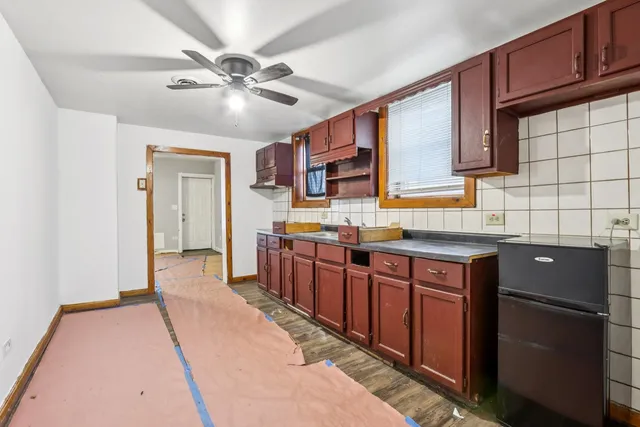 a kitchen with stainless steel appliances granite countertop a sink dishwasher stove and refrigerator with wooden floor
