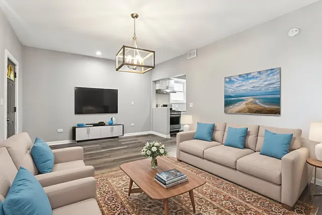 a living room with furniture a dining table and a flat screen tv