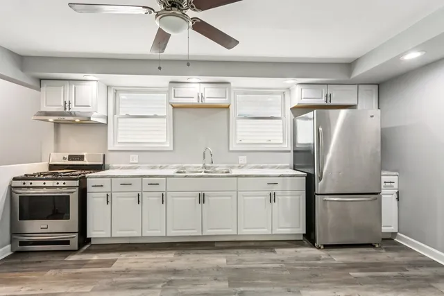 a kitchen with stainless steel appliances granite countertop a refrigerator a stove a sink and a refrigerator