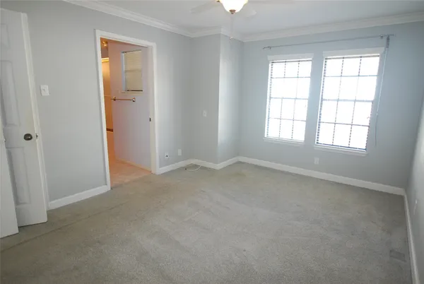 a view of an empty room with closet and a window