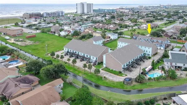 an aerial view of residential houses with outdoor space and trees