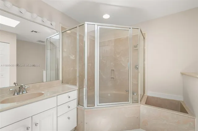 a bathroom with a shower sink and mirror