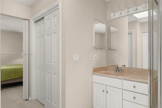 a en suite bathroom with a granite countertop sink and a mirror