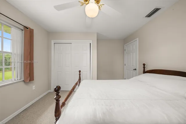 a bedroom with a bed and a dresser next to a window