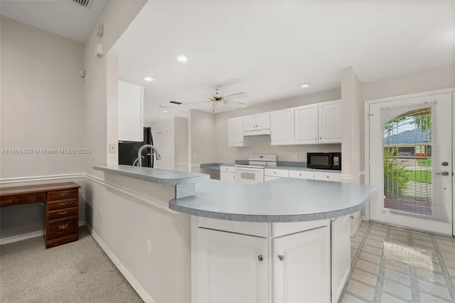 a kitchen with kitchen island a sink stainless steel appliances and cabinets
