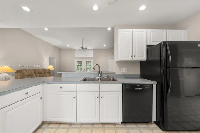 a kitchen with white cabinets and refrigerator