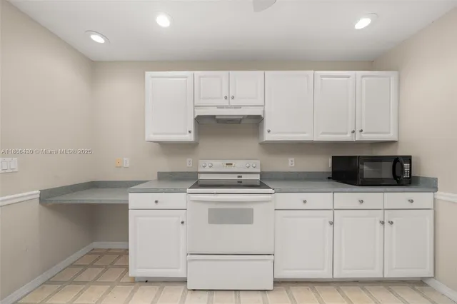 a kitchen with white cabinets and appliances