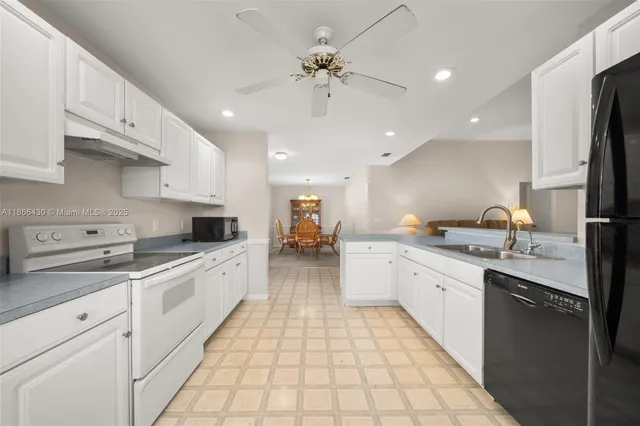 a large kitchen with stainless steel appliances granite countertop a sink and cabinets