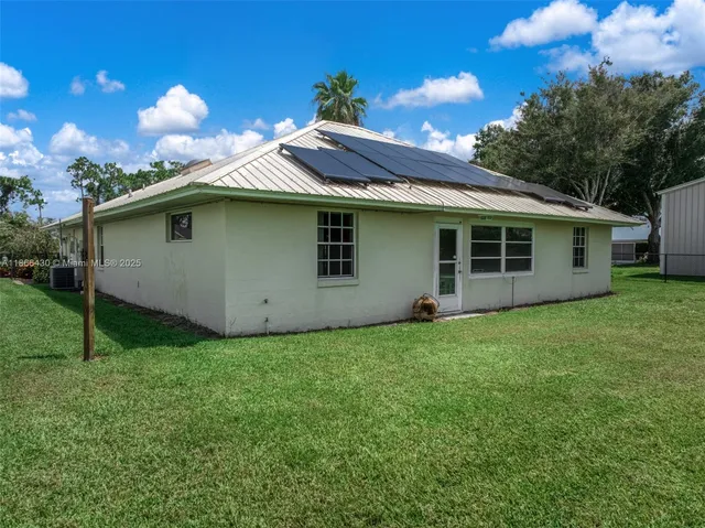 a yellow house sitting in middle of the grass