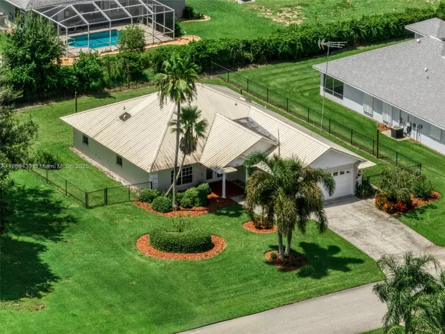 a view of a house with a yard and potted plants