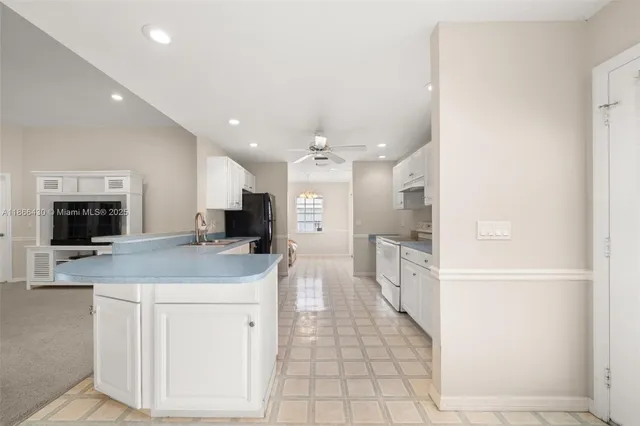 a large white kitchen with a stove a sink and a refrigerator