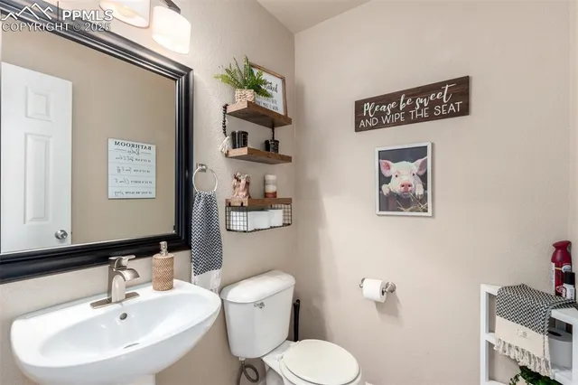 a bathroom with a toilet a sink and mirror