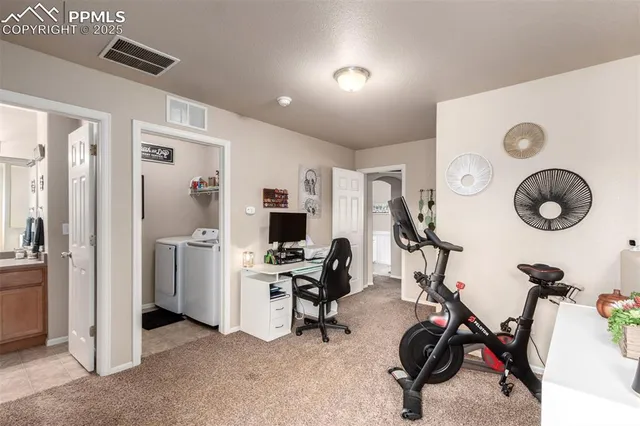 a view of a workspace with furniture and a window