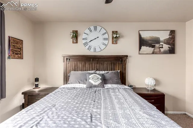 a bedroom with a bed and a lamp on dresser