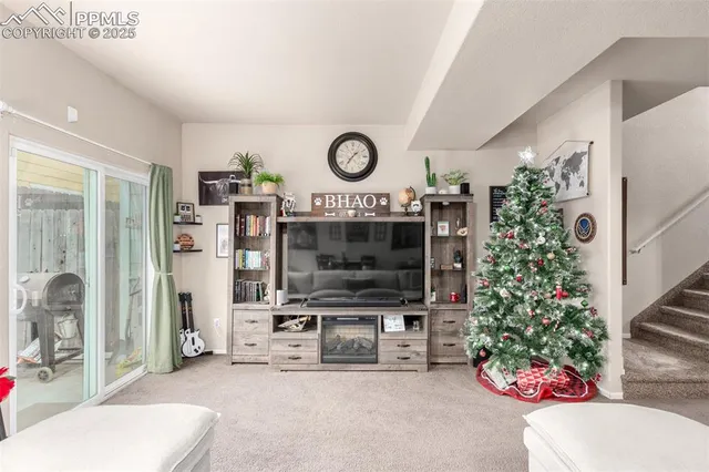 a living room with furniture a flat screen tv and a fireplace