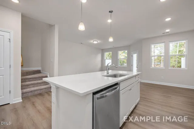 a kitchen with a sink and wooden floor