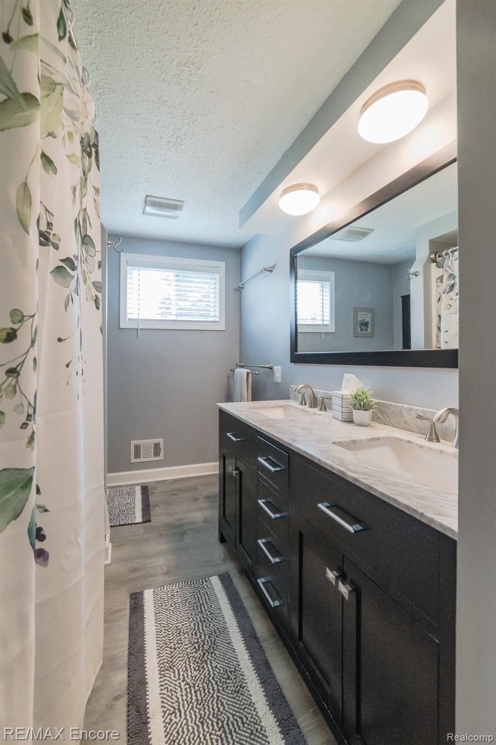 9310 Allen Road Clarkston, MI 48348 - Photo 17 of 45 Beautifully updated full bath with marble countertop and laminate wood flooring