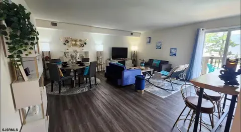 a living room with furniture dining table and a flat screen tv