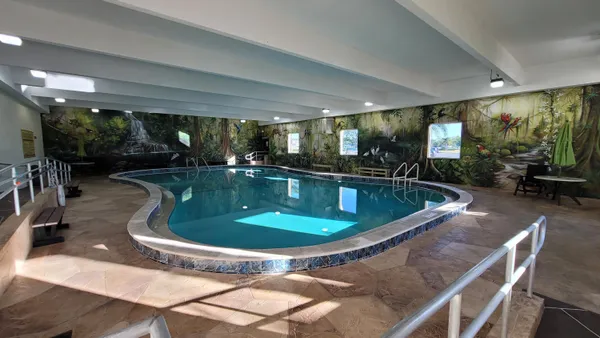 a view of a swimming pool and dining room