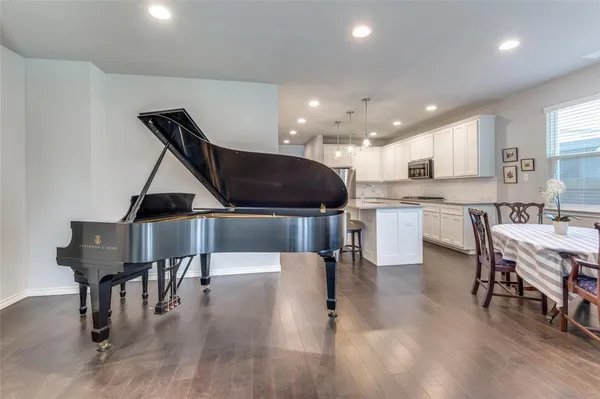 a kitchen with stainless steel appliances kitchen island granite countertop a stove a sink a dining table and chairs
