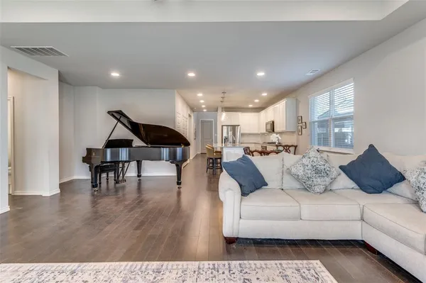 a living room with furniture and wooden floor