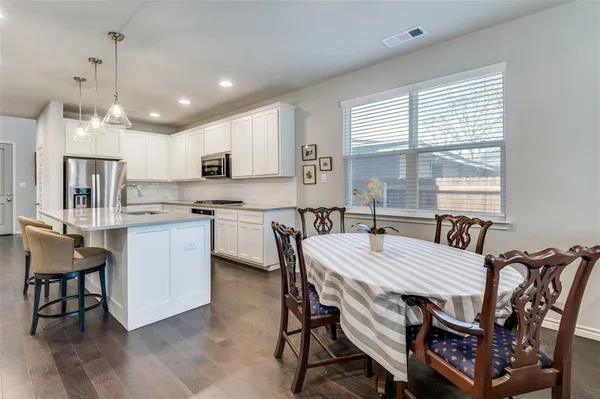a kitchen with kitchen island a dining table and chairs