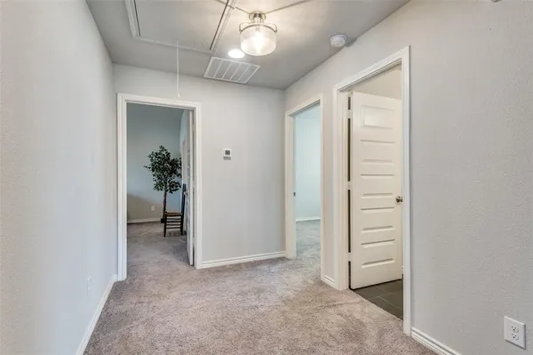 an empty room with windows and ceiling fan