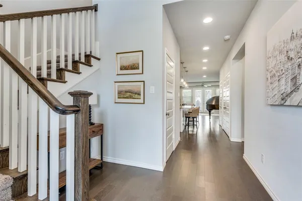 a view of a hallway with wooden floor and staircase