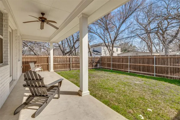 a view of a backyard with couches plants and wooden fence