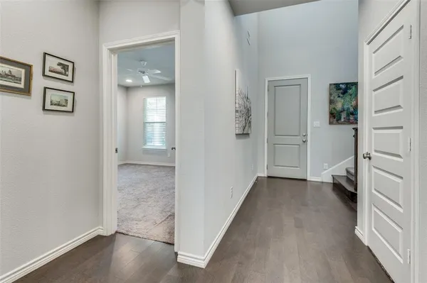 a view of a hallway with wooden floor and a bathroom