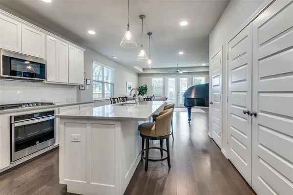 a kitchen with stainless steel appliances granite countertop a stove refrigerator sink and microwave