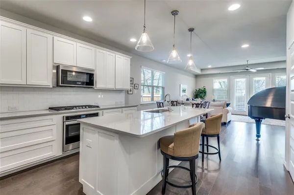 a large kitchen with stainless steel appliances granite countertop a stove a sink and a microwave