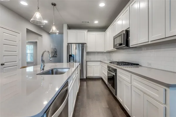 a kitchen with refrigerator a sink and cabinets