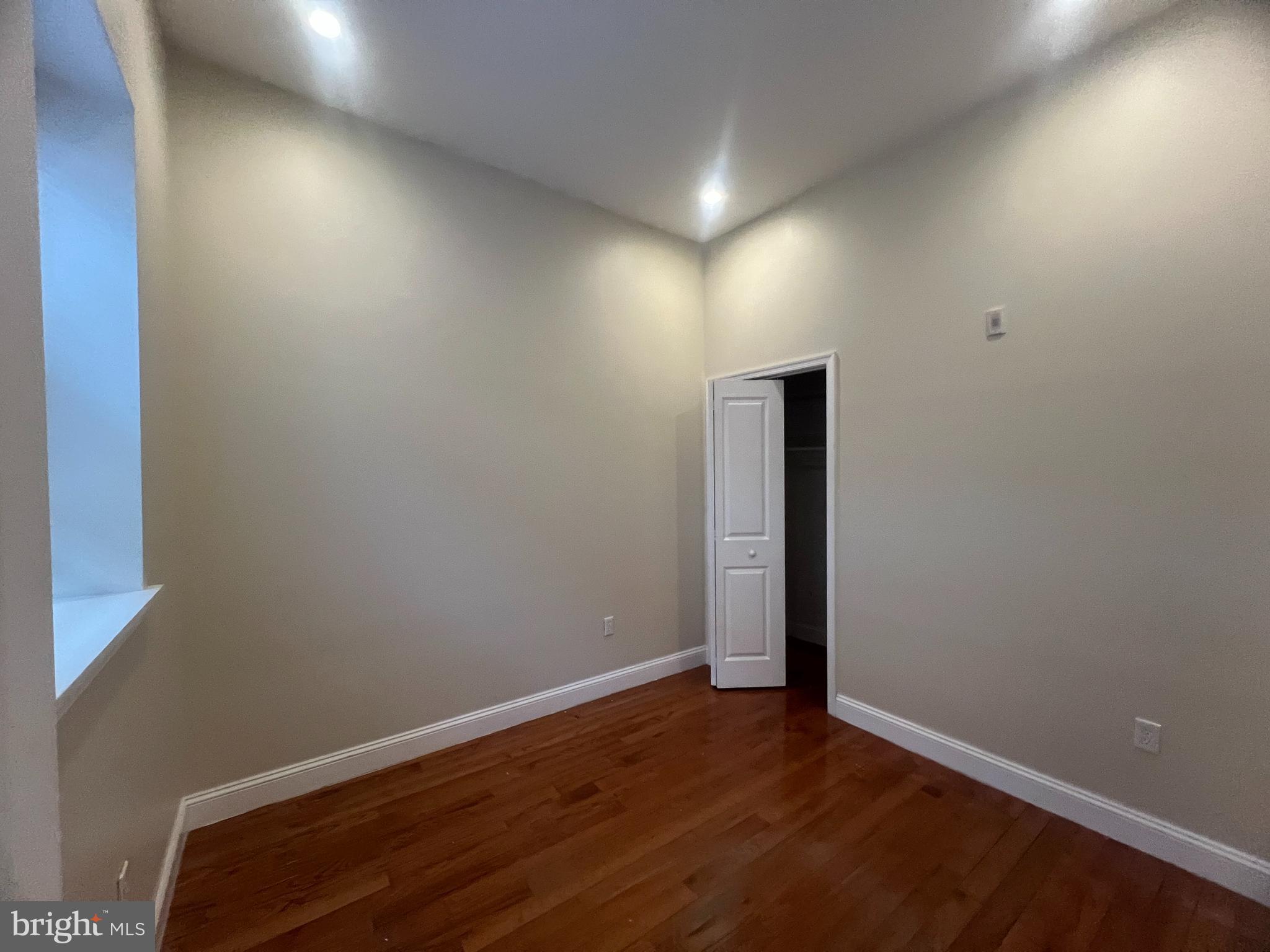 4706 Chestnut Street, Unit 4B Philadelphia, PA 19139 - Photo 6 of 7 an empty room with wooden floor and windows