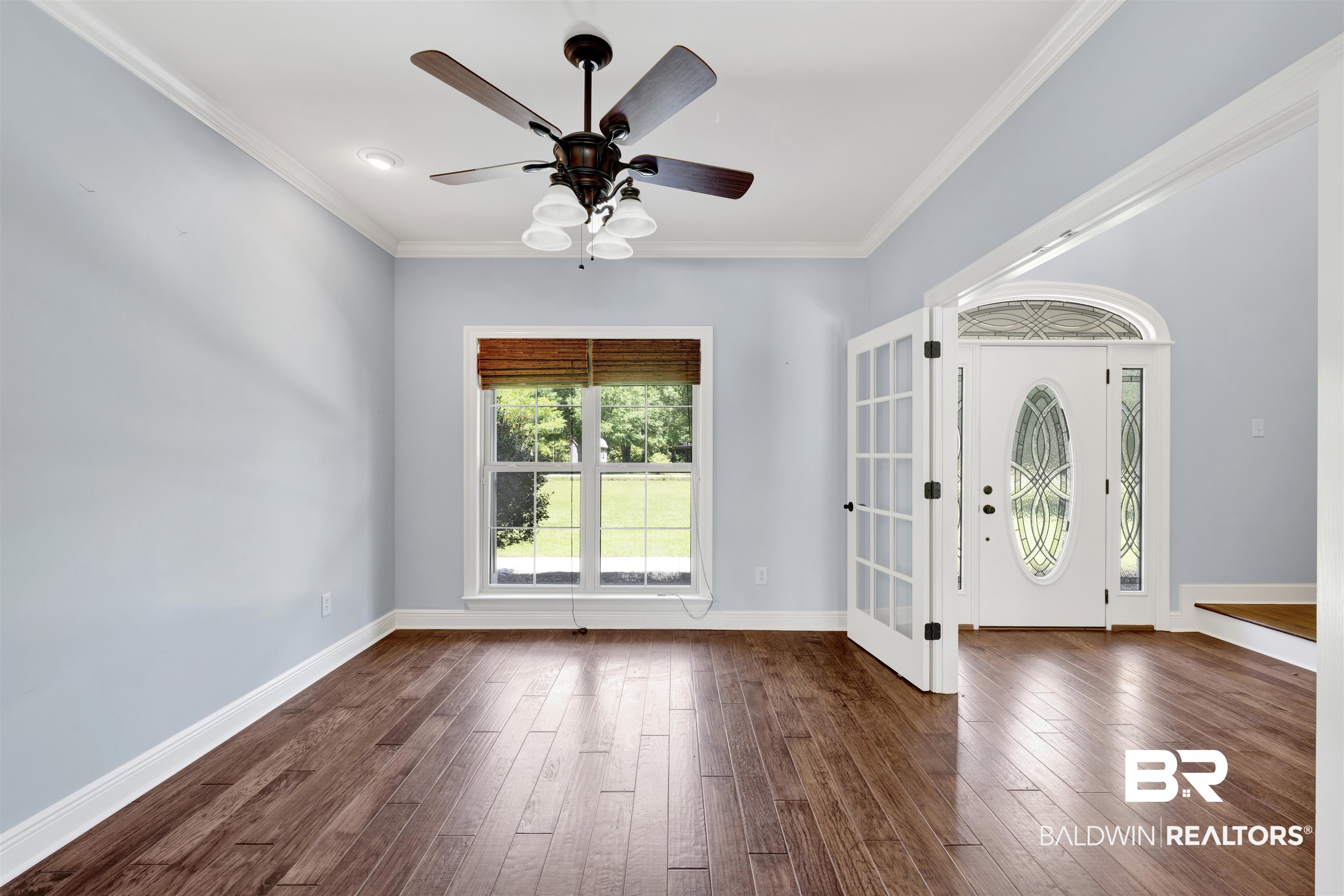 12944 Anna's Way Stapleton, AL 36578 - Photo 45 of 64 Spacious interior room featuring wood-finish flooring, a ceiling fan with integrated lighting, and a large window with a woven shade