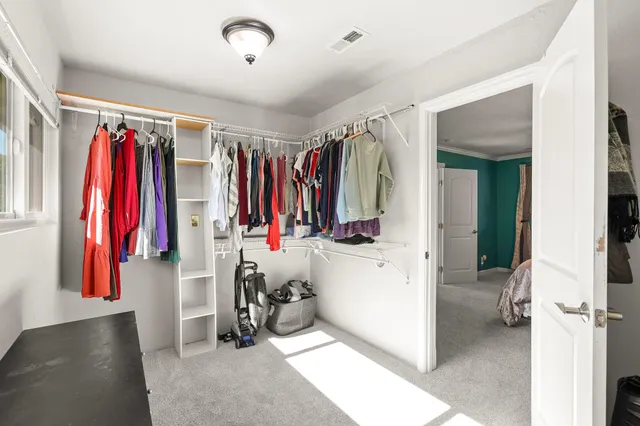 a view of walk in closet with clothes and shoes