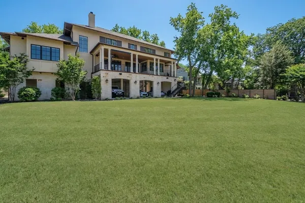 a view of house with yard and trees in the background