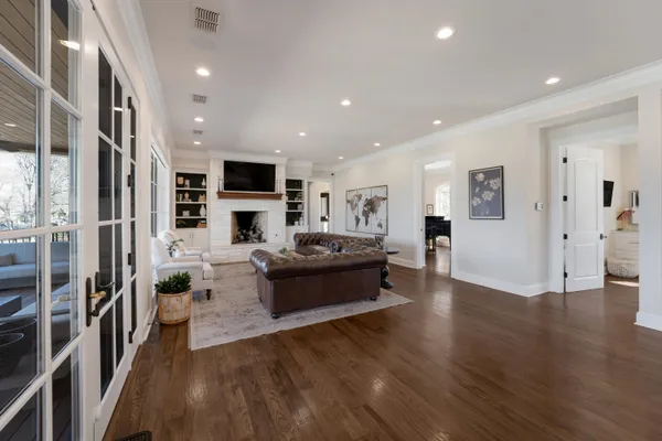 a large living room with stainless steel appliances wooden floor and a kitchen view
