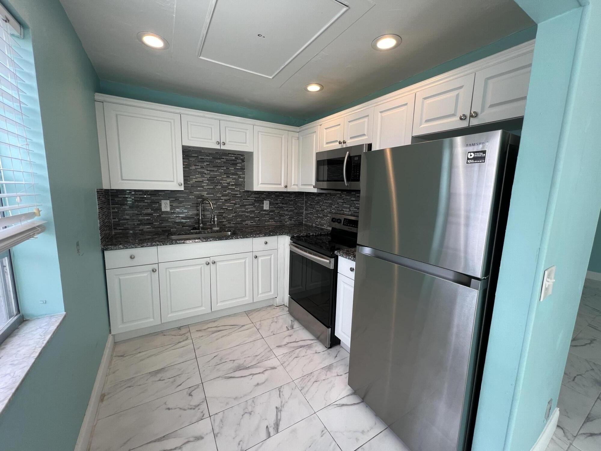 a kitchen with a refrigerator a sink and cabinets