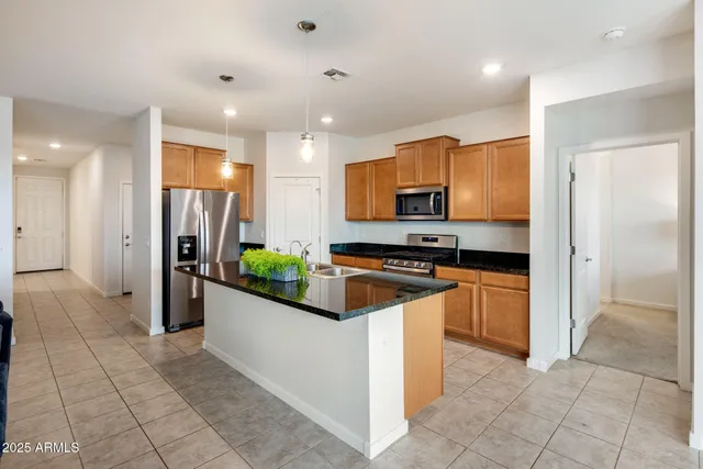 a kitchen with stainless steel appliances granite countertop a refrigerator and a stove