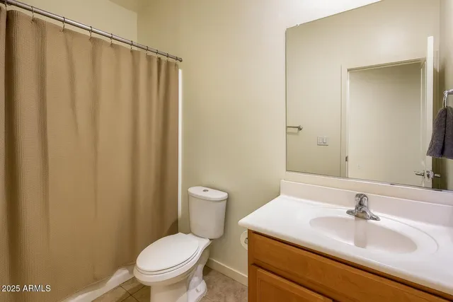 a bathroom with a sink a toilet and shower curtain