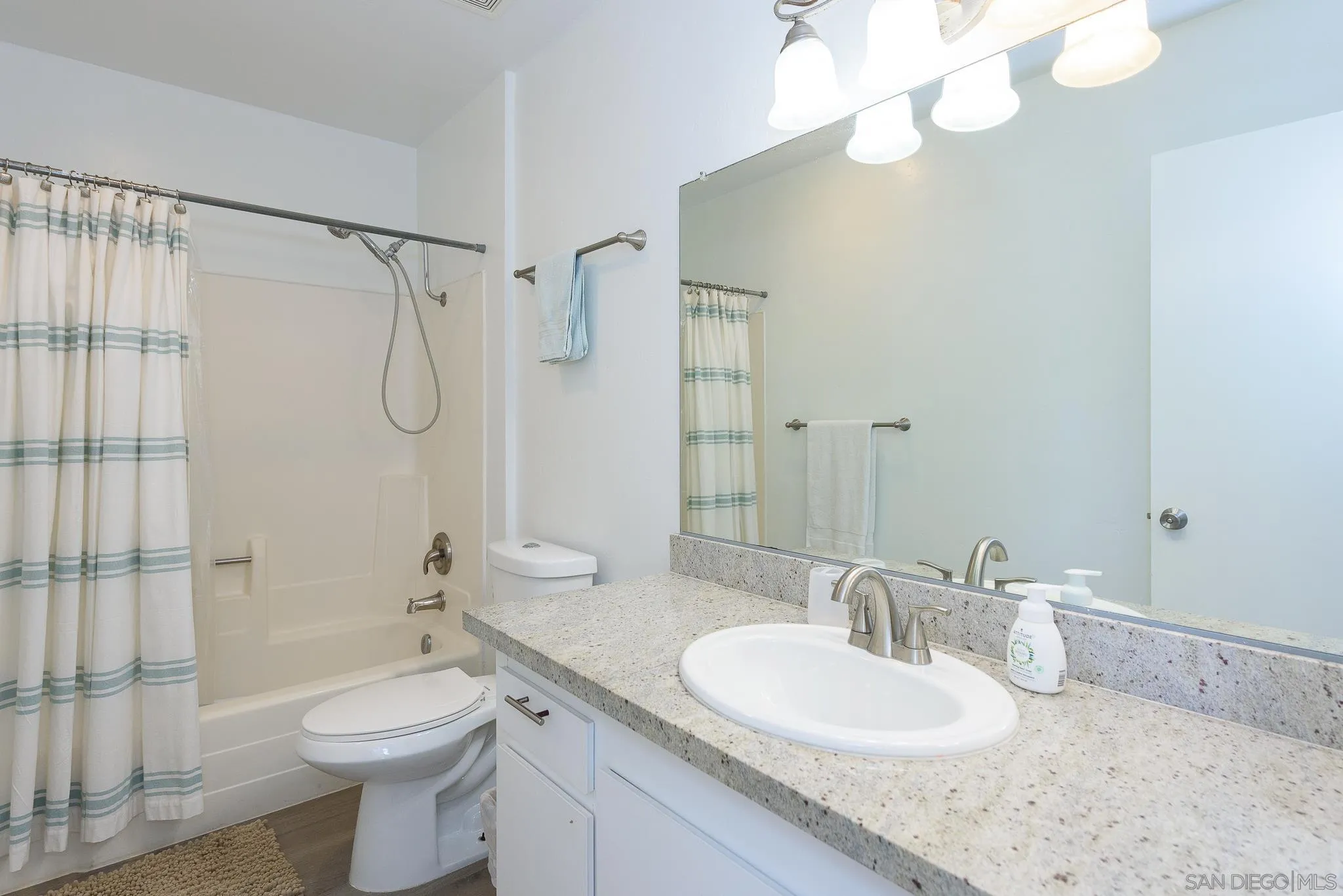 712 Silver Drive Vista, CA 92083 - Photo 19 of 32 a bathroom with a granite countertop sink toilet a mirror and shower
