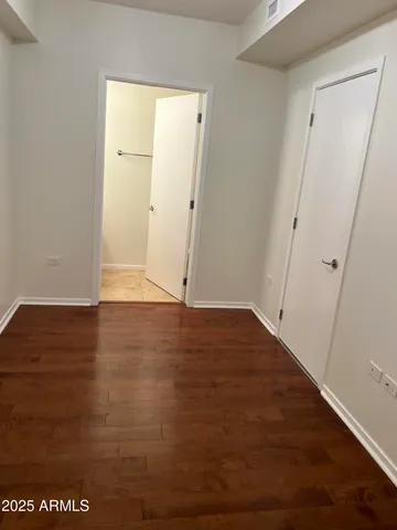 an empty room with wooden floor and entrance