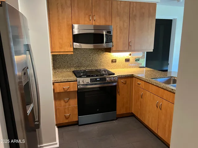 a kitchen with stainless steel appliances wooden cabinets and a stove top oven
