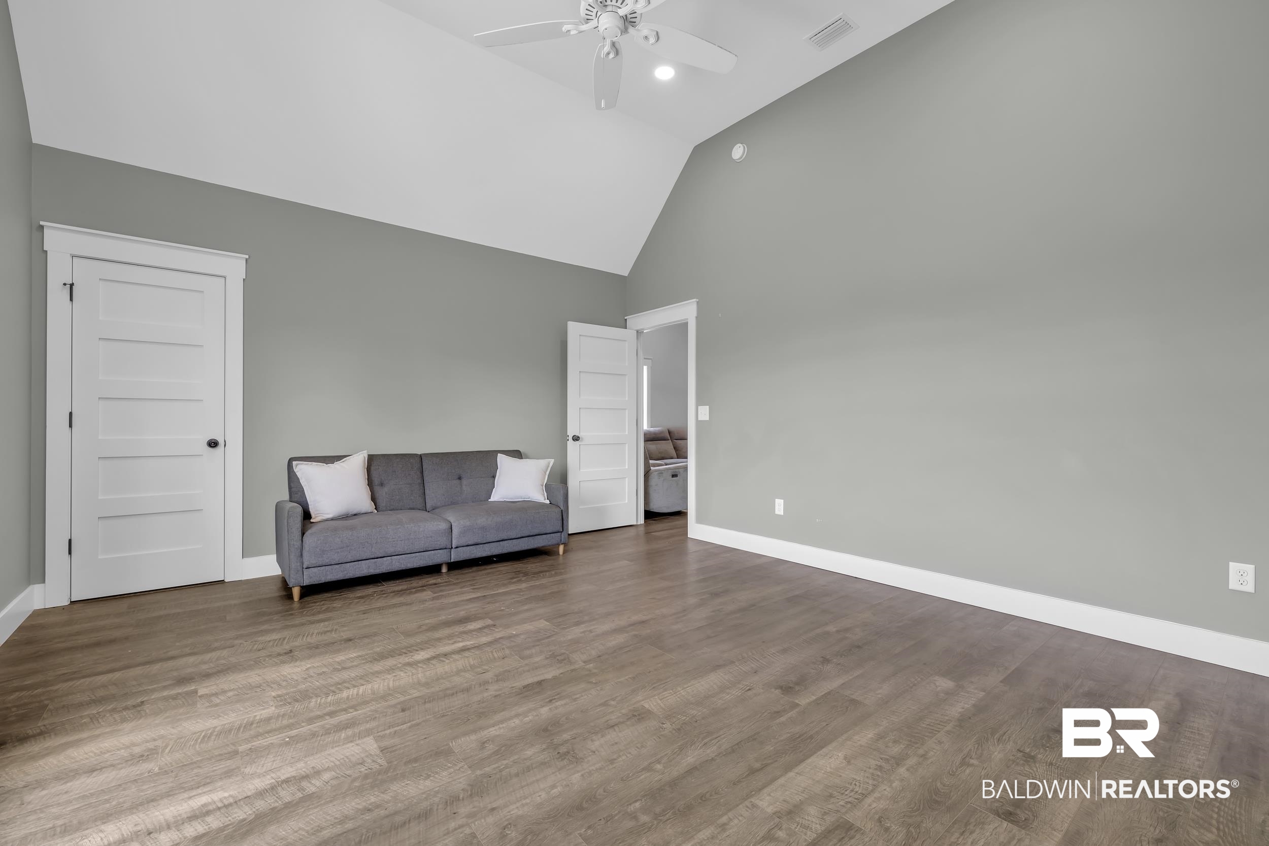 6576 Ranch Loop Road East Grand Bay, AL 36541 - Photo 26 of 39 Spacious room featuring vaulted ceilings, wood-finish flooring, and white trim