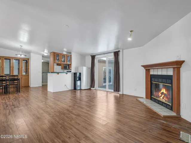 a view of a livingroom with a kitchen and a fireplace