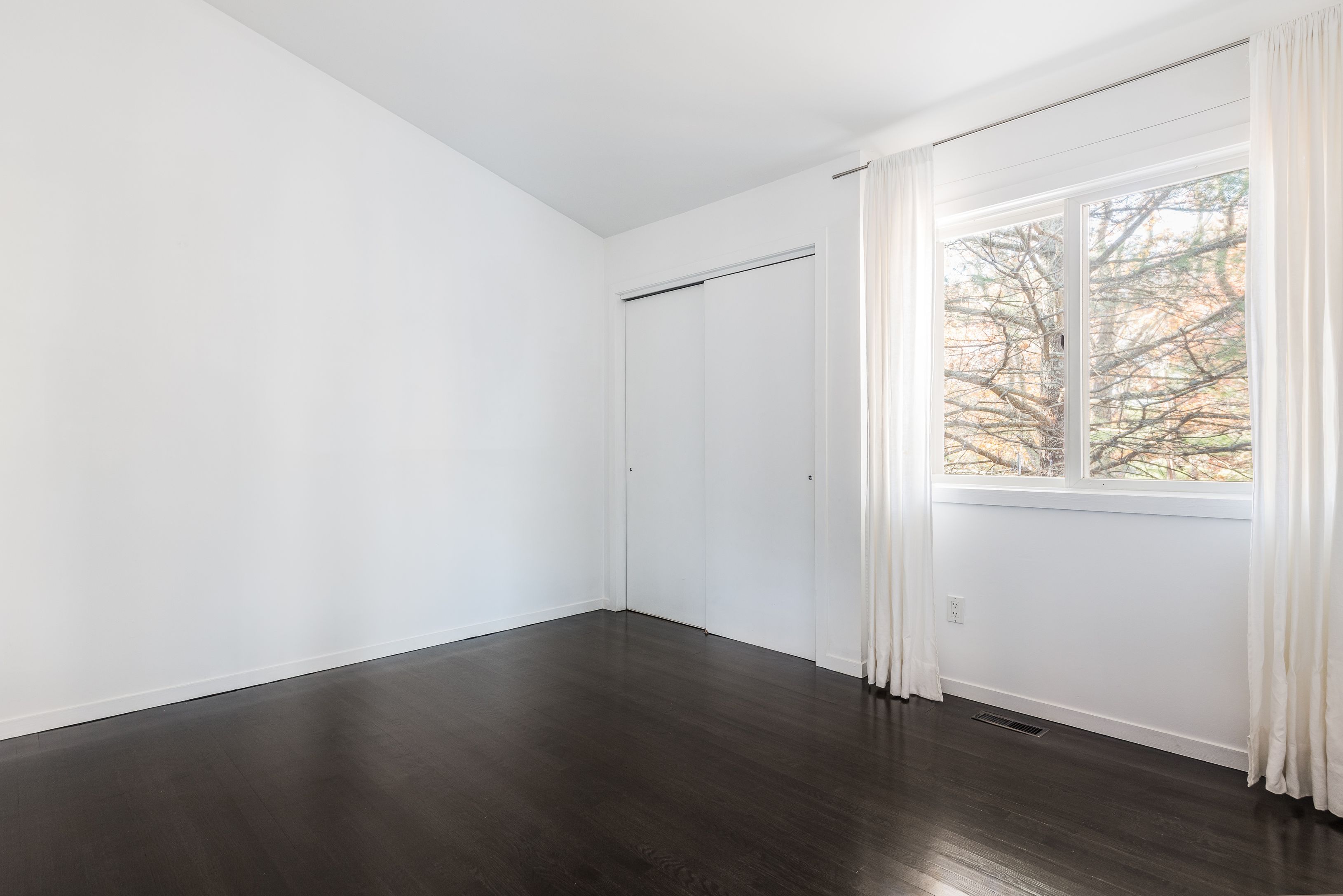 132 Springy Banks Road East Hampton, NY 11937 - Photo 24 of 35 an empty room with wooden floor and windows